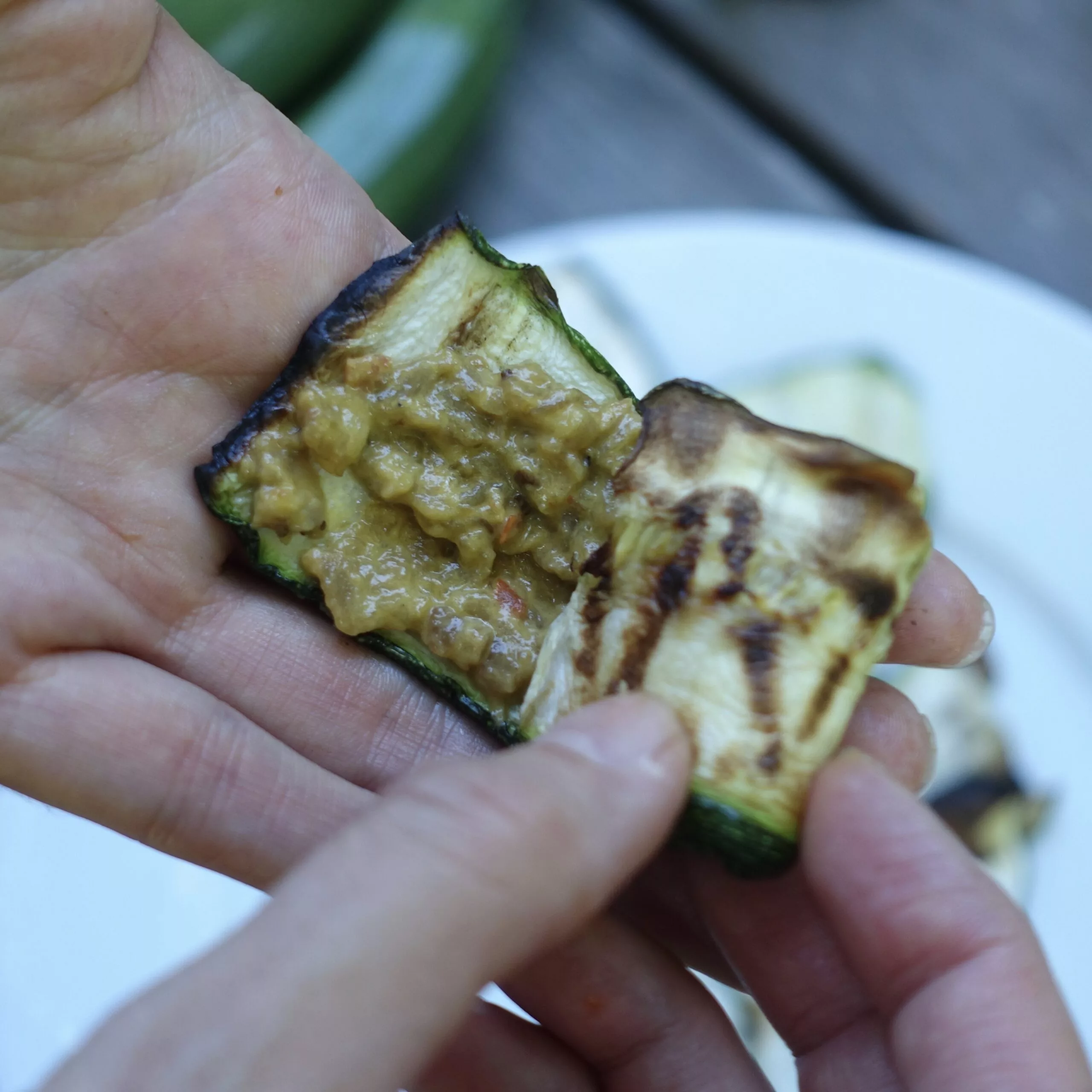 Die Zucchinischeiben werden mit Pinđur und Maliđano bestrichen und eingerollt.